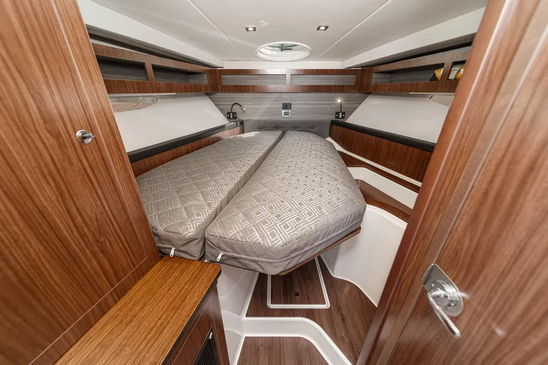 Slide: The Image of 2020 Four Winns Vista 355 Coupe OB cabin interior with wood finish and cozy bed. - 43