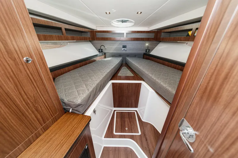 Slide: The Image of 2020 Four Winns Vista 355 Coupe OB cabin interior with wood finish and twin beds. - 44