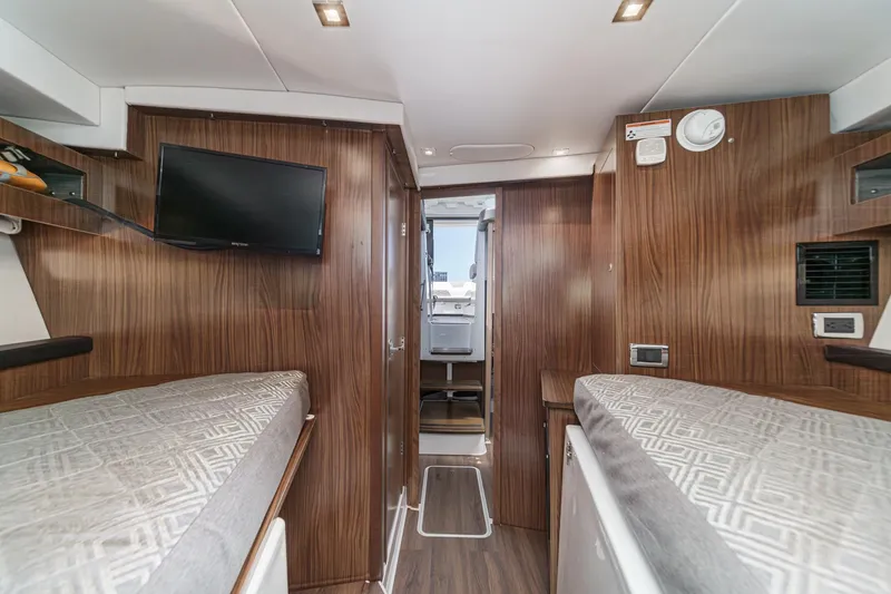 Slide: The Image of Interior of 2020 Four Winns Vista 355 Coupe OB with wood paneling and twin beds. - 45