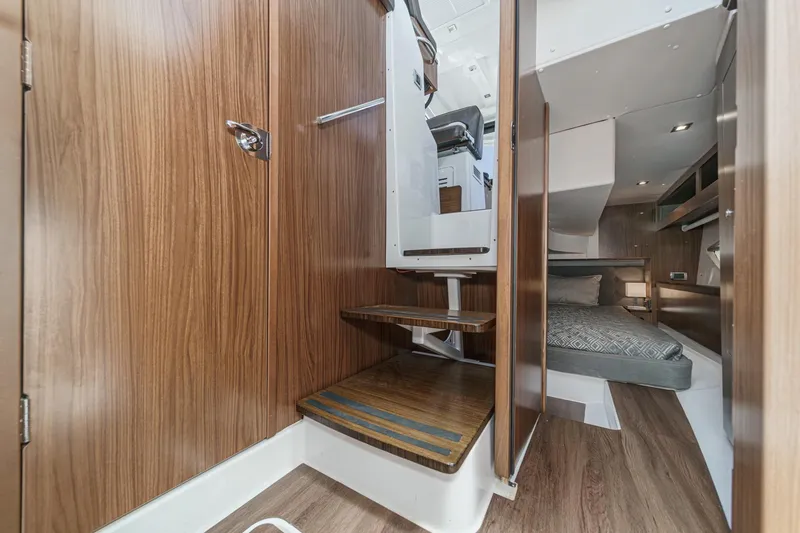 Slide: The Image of Interior of 2020 Four Winns Vista 355 Coupe OB, featuring wood paneling and cozy sleeping area. - 49