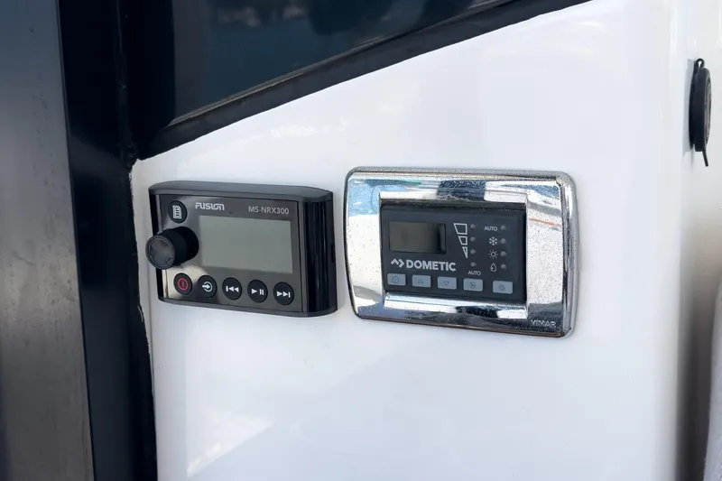 Slide: The Image of Control panels on 2020 Four Winns Vista 355 Coupe OB boat, featuring Fusion and Dometic systems. - 60
