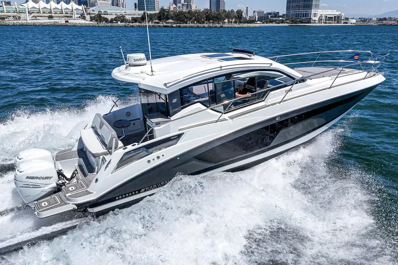 Slide: The Image of 2020 Four Winns Vista 355 Coupe OB cruising on water, cityscape in background. - 9