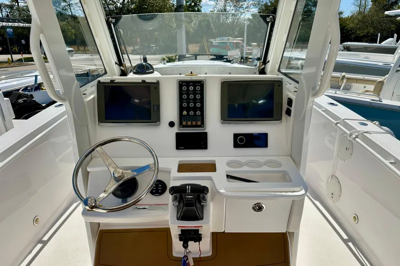 Slide: The Image of 2013 Everglades 325 Center Console boat with powerful outboard engine, parked on a trailer. - 1