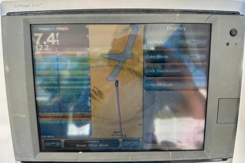 Slide: The Image of 2013 Everglades 325 Center Console boat dashboard with steering wheel and navigation screens. - 12