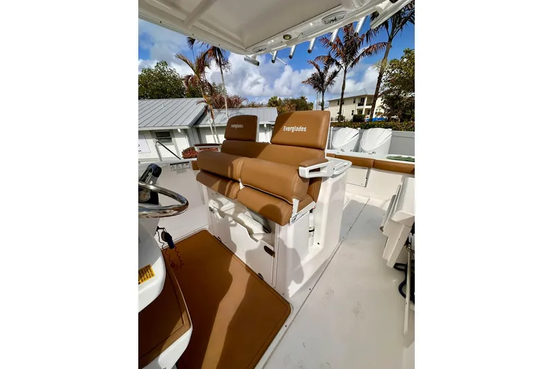 Slide: The Image of 2013 Everglades 325 Center Console boat interior with tan seating and steering wheel. - 19
