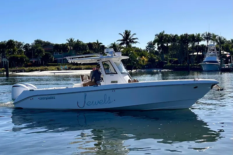 Slide: The Image of 2013 Everglades 325 Center Console boat on calm water, with palm trees in the background. - 31