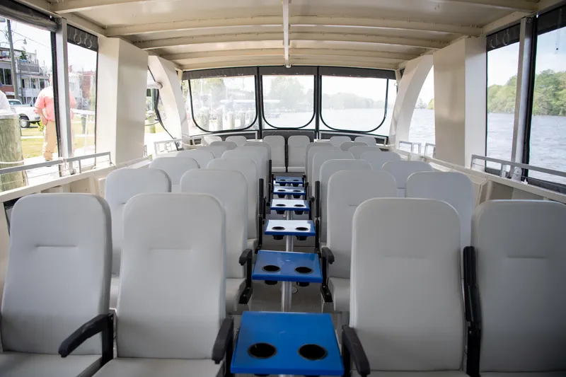 Slide: The Image of Interior of 2023 Smoky Mountain asymmetrical foil-assisted catamaran with white seating and blue tables. - 7
