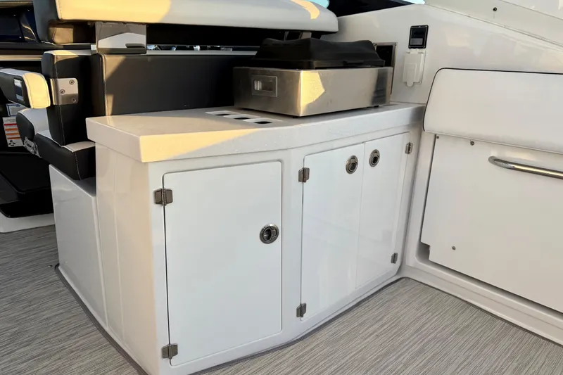 Slide: The Image of 2022 Monterey 385SS Super Sport boat interior with sleek white cabinetry and grill. - 12