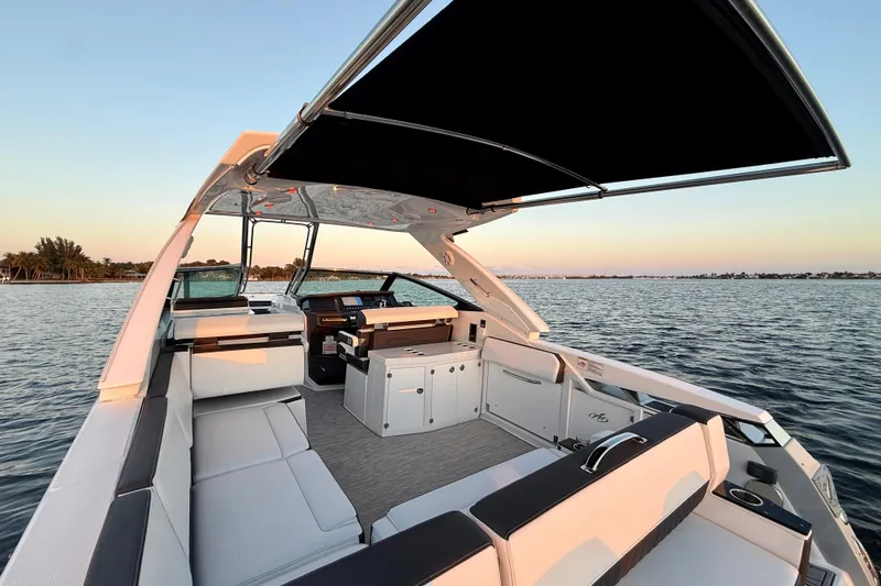 Slide: The Image of 2022 Monterey 385SS Super Sport boat interior with seating and canopy on calm water. - 17