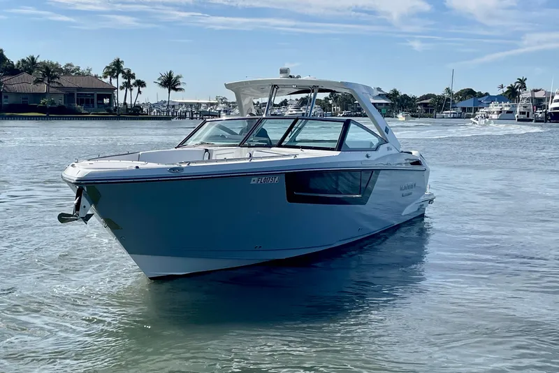 Slide: The Image of 2022 Monterey 385SS Super Sport boat on calm water, with coastal background. - 2