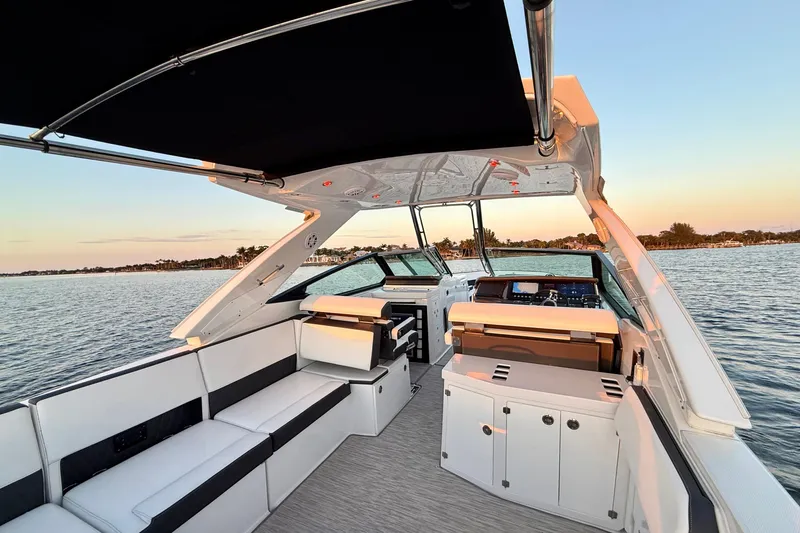 Slide: The Image of 2022 Monterey 385SS Super Sport boat interior with sleek seating and modern dashboard on calm water. - 23