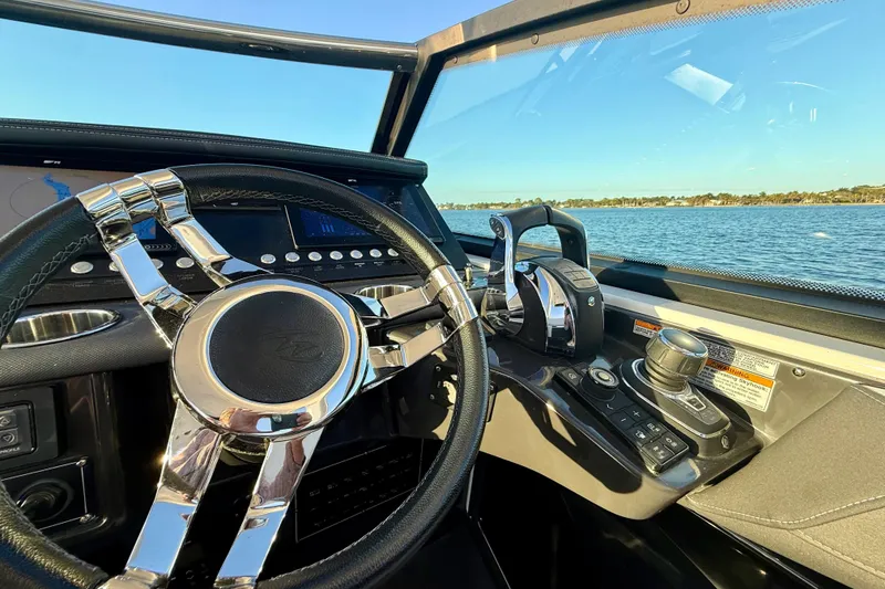 Slide: The Image of 2022 Monterey 385SS Super Sport boat dashboard with steering wheel and controls, overlooking water. - 3
