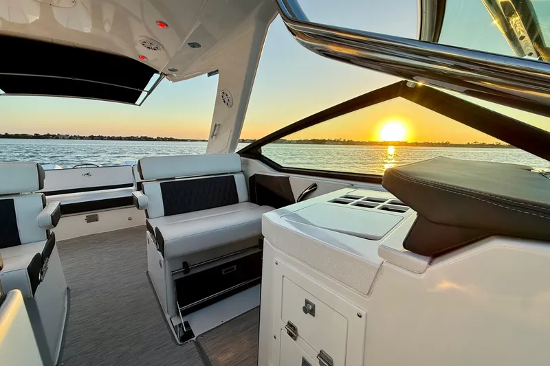Slide: The Image of 2022 Monterey 385SS Super Sport boat interior at sunset on the water. - 16