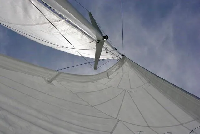 Slide: The Image of Sailboat with white sails against a clear sky, Hughes 40 model, 2012. - 12