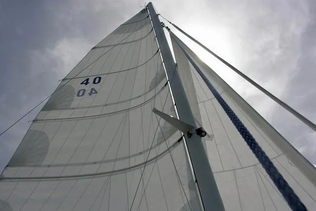 Slide: The Image of Sailboat mast and sails of Hughes 40, 2012 model, against cloudy sky. - 13