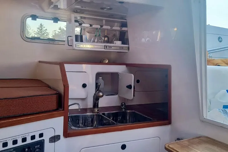 Slide: The Image of Compact kitchen area in a 2012 Hughes 40 yacht, featuring a sink and storage. - 18