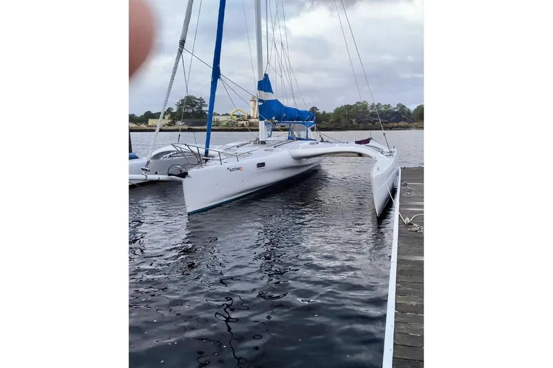 Slide: The Image of Sleek 2012 Kurt Hughes 40 trimaran docked on calm waters. - 2