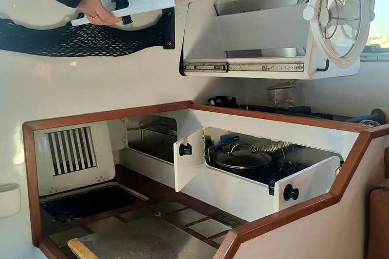 Slide: The Image of Compact kitchen area in a 2012 Hughes 40 boat, featuring storage and cooking space. - 21