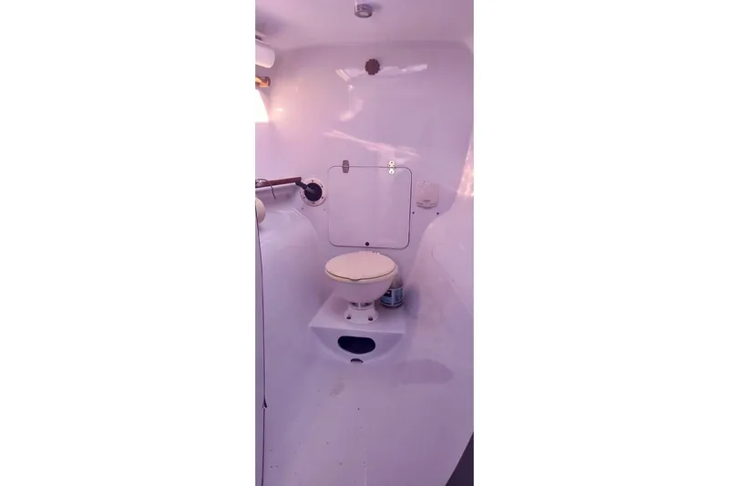 Slide: The Image of Compact marine bathroom in a 2012 Hughes 40 sailboat, featuring a toilet and storage. - 32