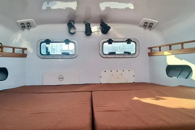 Slide: The Image of Interior of a 2012 Hughes 40 camper with brown cushions and small windows. - 39