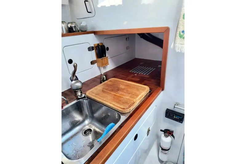 Slide: The Image of Compact kitchen area in a 2012 Kurt Hughes 40 boat, featuring a sink and cutting board. - 5