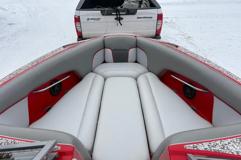 Slide: The Image of 2006 Centurion Enzo SV230 boat interior with red and gray seating, parked on snow. - 13
