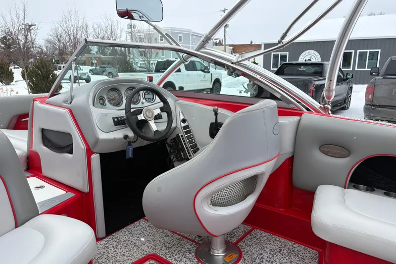 Slide: The Image of 2006 Centurion Enzo SV230 boat interior with red and gray seating, steering wheel, and dashboard. - 7
