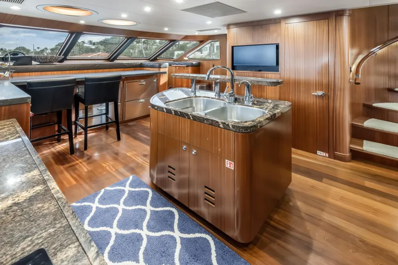 Slide: The Image of Luxurious 2012 Cheoy Lee 84 Bravo yacht interior with modern kitchen and elegant wood finishes. - 15