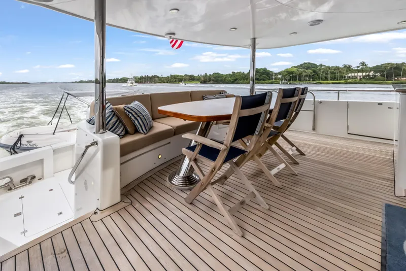 Slide: The Image of Outdoor dining area on 2012 Cheoy Lee 84 Bravo yacht, featuring wooden deck and scenic water view. - 7