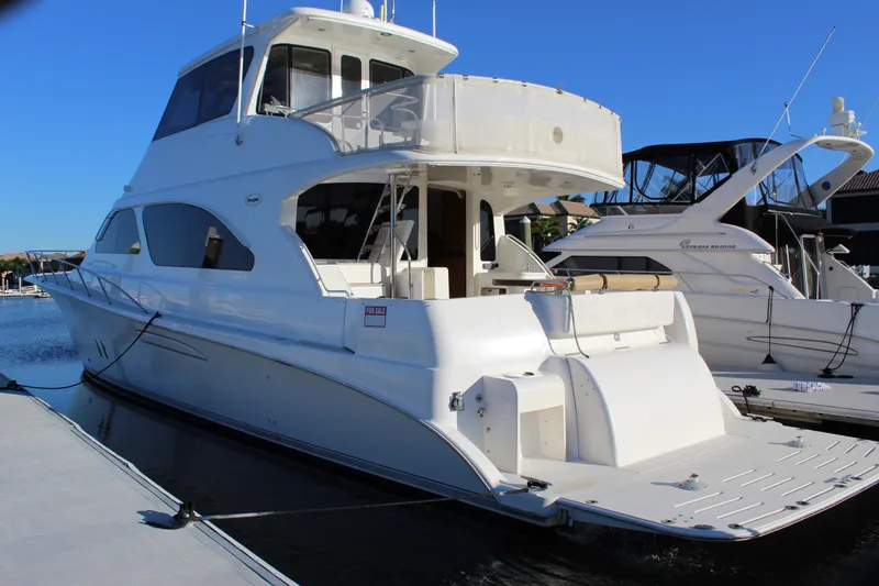 Slide: The Image of 2003 Ocean Yachts 65 Odyssey docked, showcasing sleek design and spacious deck. - 11