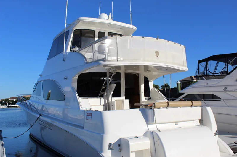 Slide: The Image of 2003 Ocean Yachts 65 Odyssey docked, showcasing sleek design and spacious upper deck. - 13