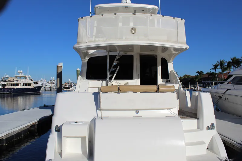 Slide: The Image of 2003 Ocean Yachts 65 Odyssey docked at marina under clear blue sky. - 14