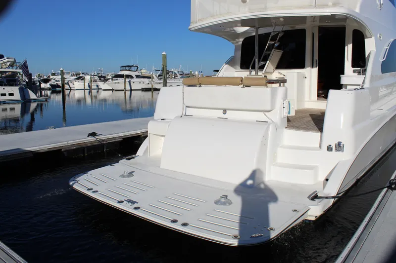 Slide: The Image of 2003 Ocean Yachts 65 Odyssey docked at marina, showcasing spacious deck and elegant design. - 16