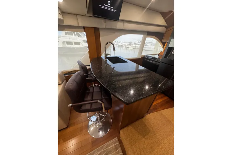 Slide: The Image of Luxurious interior of 2003 Ocean Yachts 65 Odyssey with modern furnishings and spiral staircase. - 27