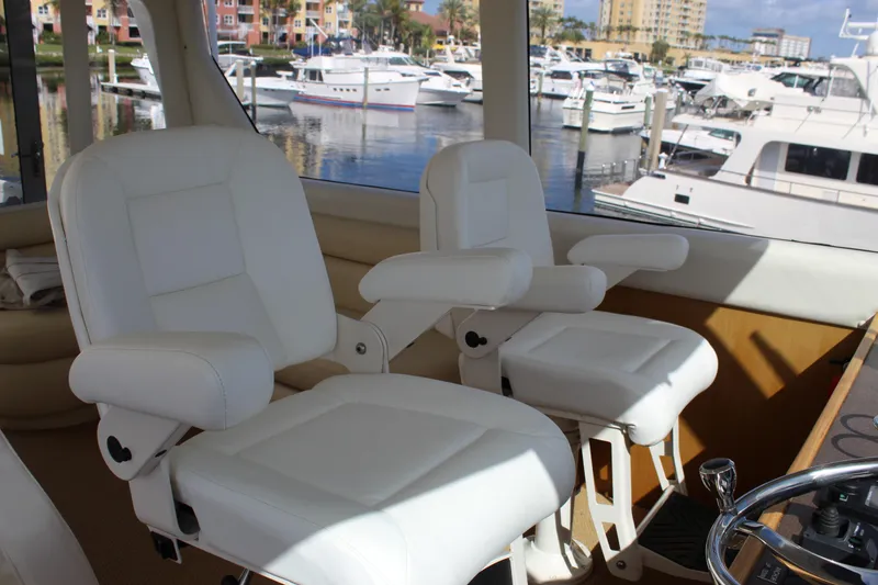 Slide: The Image of Luxurious white captain chairs on 2003 Ocean Yachts 65 Odyssey, overlooking marina. - 48