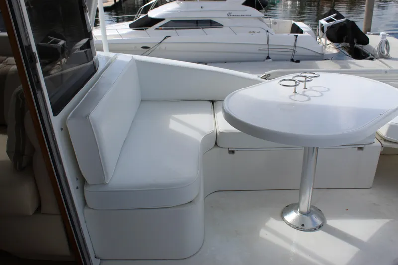 Slide: The Image of 2003 Ocean Yachts 65 Odyssey interior with white seating and table. - 54