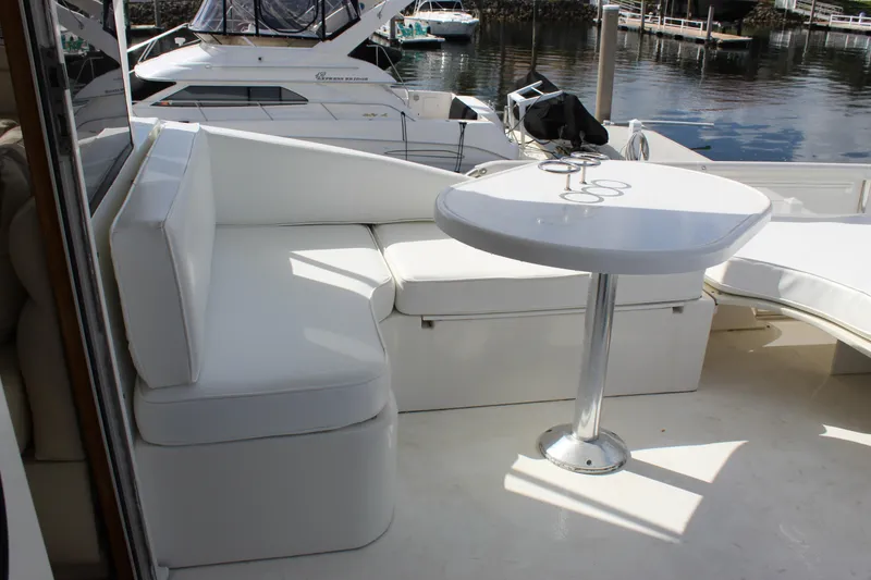 Slide: The Image of Luxurious seating area on a 2003 Ocean Yachts 65 Odyssey, docked at a marina. - 56