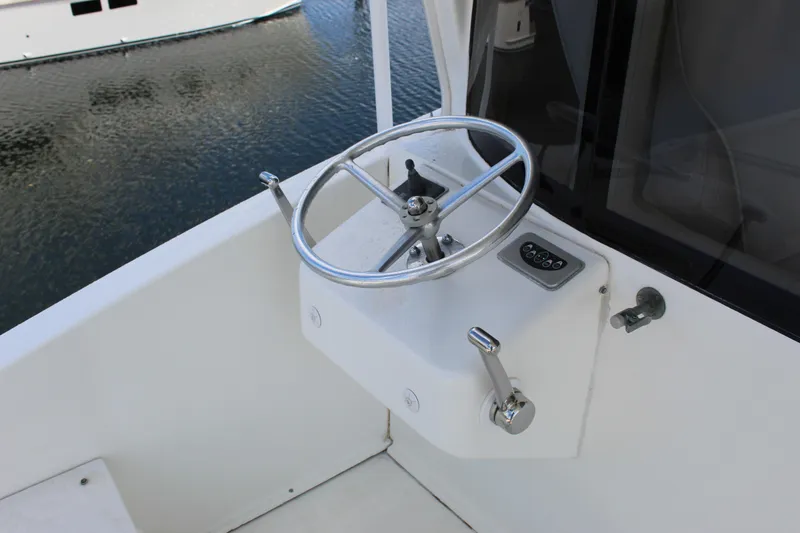 Slide: The Image of Steering wheel of a 2003 Ocean Yachts 65 Odyssey boat, docked on calm water. - 58