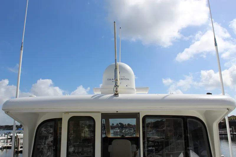 Slide: The Image of 2003 Ocean Yachts 65 Odyssey yacht with radar, under a bright blue sky. - 62