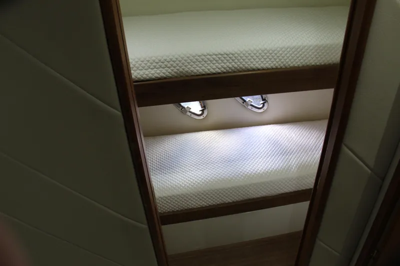 Slide: The Image of Bunk beds in 2003 Ocean Yachts 65 Odyssey, featuring cozy white mattresses and porthole windows. - 67