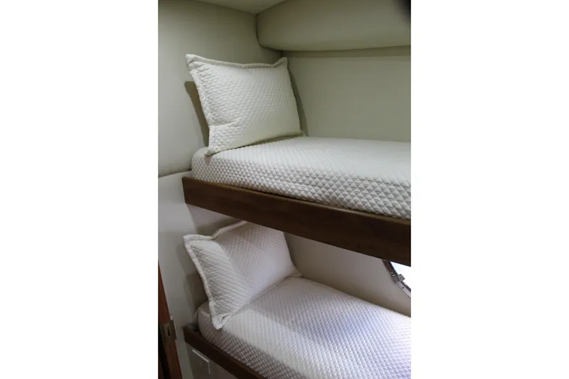 Slide: The Image of Bunk beds in 2003 Ocean Yachts 65 Odyssey, featuring white quilted bedding. - 68