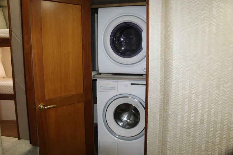Slide: The Image of Laundry area with stacked washer and dryer in 2003 Ocean Yachts 65 Odyssey. - 74