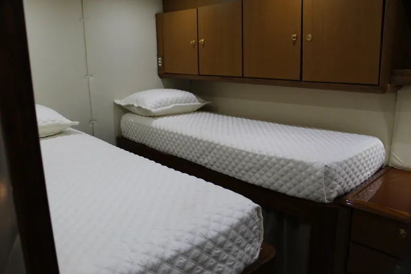 Slide: The Image of Twin beds in a 2003 Ocean Yachts 65 Odyssey cabin with wooden cabinets. - 77