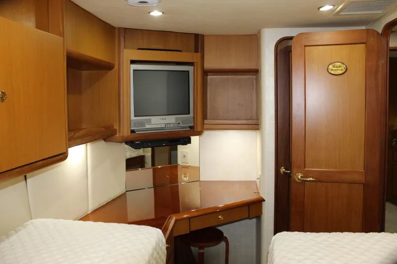 Slide: The Image of Luxurious 2003 Ocean Yachts 65 Odyssey cabin with TV and wooden interior. - 80