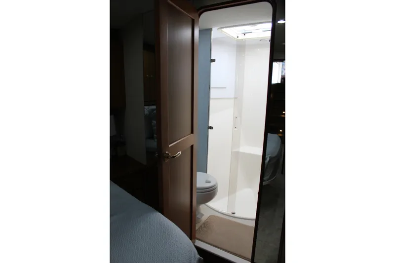 Slide: The Image of Bathroom interior of 2003 Ocean Yachts 65 Odyssey, featuring a compact shower and toilet. - 86