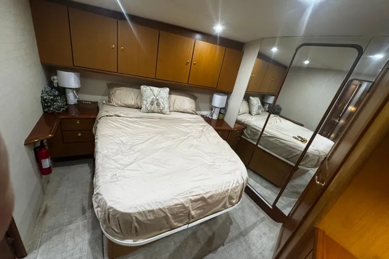 Slide: The Image of Luxurious bedroom interior of 2003 Ocean Yachts 65 Odyssey with mirrored closet and wooden cabinets. - 32