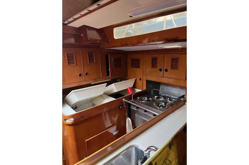 Slide: The Image of 1980 SKYE 51 yacht interior with wooden cabinets, stove, and sink. - 2