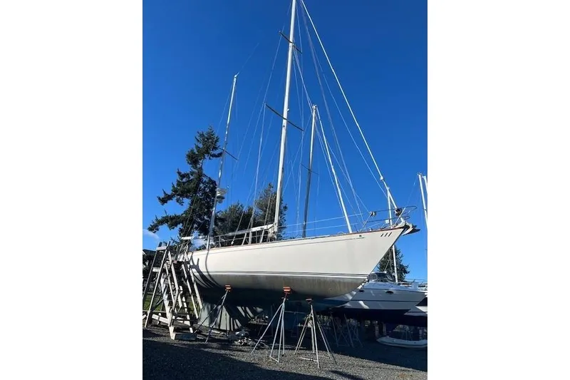 The Image of 1980 Ketch Alden sailboat on stands, clear blue sky background. - 0