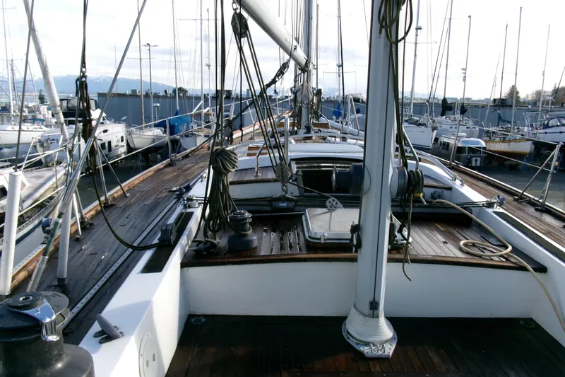Slide: The Image of 1980 Ketch 51 sailboat deck with rigging in a marina setting. - 17