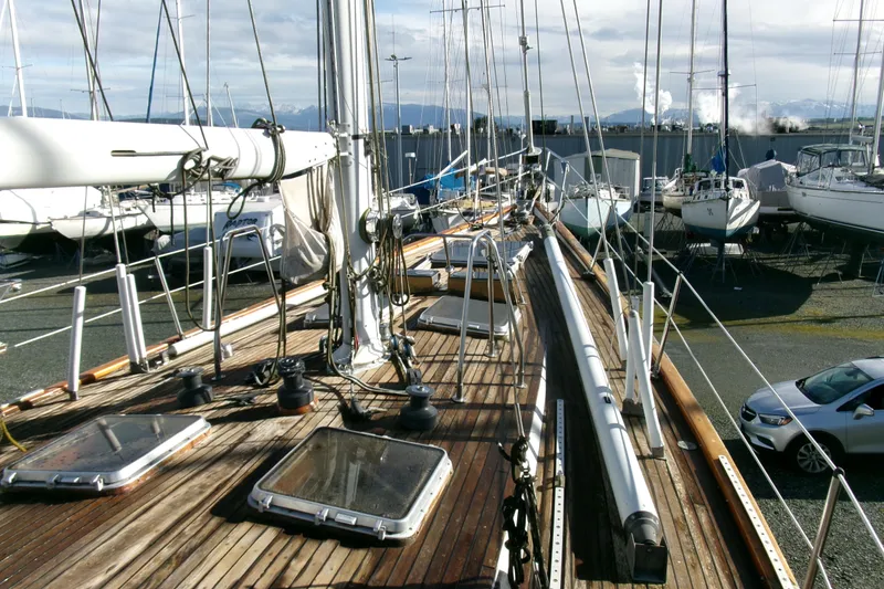 Slide: The Image of 1980 Ketch 51 sailboat on deck, surrounded by other boats in a marina. - 9